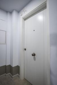 a white door with a number on it in a room at Ibericabeds Granada in Granada