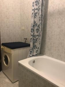 ein Badezimmer mit einer Badewanne und einer Waschmaschine in der Unterkunft Apartment Vesna in Veleniki