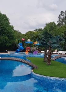 a large swimming pool with a playground in a park at Hotel Elit Palace and SPA in Balchik