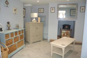 a living room with a table and a dresser and a fireplace at Higher Brockwell Annexe in Wootton Courtenay