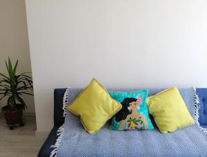 ラ・セレナにあるDepartamento avenida del marの青いソファーに座る人形(枕付) +6枚の写真