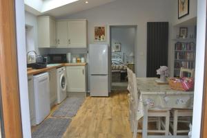 a kitchen and dining room with a table and refrigerator at Higher Brockwell Annexe in Wootton Courtenay