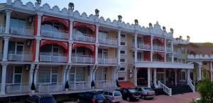 a large building with cars parked in front of it at Hotel Elit Palace and SPA in Balchik