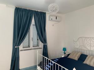 a bedroom with a blue bed and a window at Residence Serrone in Santa Maria di Castellabate +71 photos