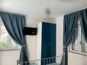 a bedroom with blue curtains and a crib at Residence Serrone in Santa Maria di Castellabate