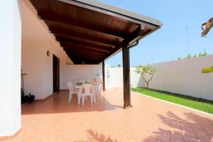 a patio with a table and chairs under awning at Villetta Mirtillo by TerraSalento in Torre dell'Orso +24 photos