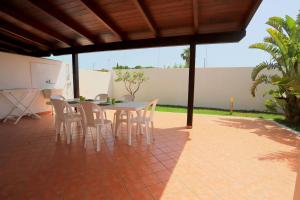a patio with a table and chairs under a pavilion at Villetta Mirtillo by TerraSalento in Torre dell'Orso