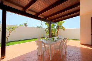 a white table and chairs on a patio at Villetta Mirtillo by TerraSalento in Torre dell'Orso