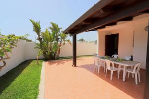 a patio with a table and chairs in a house at Villetta Mirtillo by TerraSalento in Torre dell'Orso
