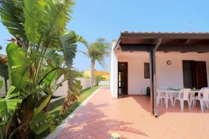 a patio of a house with a table and chairs at Villetta Mirtillo by TerraSalento in Torre dell'Orso