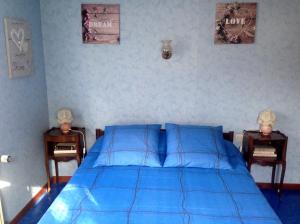 1 dormitorio con 1 cama azul y 2 mesitas de noche en Chambres d'hôtes et Gîte chez Martine, en Barr