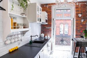 a kitchen with a sink and a brick wall at Apartamenty Pocztowa in Bydgoszcz