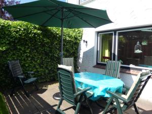 a table and chairs with an umbrella on a patio at Haus Jane in Dornum
