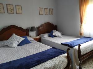 a bedroom with two beds with blue sheets at Casa Rural Villa de Ambel in Ambel