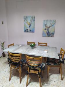 a dining room table with chairs and paintings on the wall at Casa Rural Villa de Ambel in Ambel +14 photos