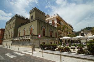 a large building on a street with umbrellas at Palazzo Durante in Letojanni