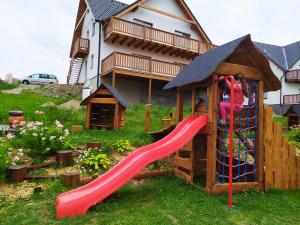 a playground with a slide in front of a house at Apartmany Podhorama in Vaclavov u Bruntalu