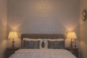 um quarto com uma cama com almofadas e 2 candeeiros em Luxury Apartment Padre Pio em Split