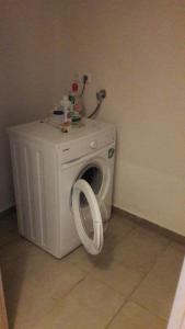 a white washing machine in a corner of a room at Апартаменты Елена in Nea Peramos