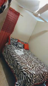 a bedroom with a zebra print bed with a ceiling at Apartahotel carla in Boca Chica