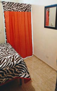 a room with a bed and a red curtain at Apartahotel carla in Boca Chica