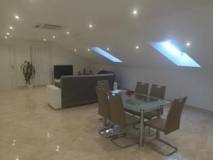 - une salle à manger avec une table, des chaises et des lucarnes dans l'établissement Apartman Daria, à Trogir