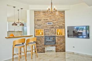 a kitchen with two bar stools and a brick wall at Villa My Soul in Herceg-Novi