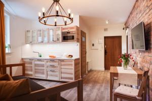 a kitchen with white cabinets and a brick wall at Apartamenty Pocztowa in Bydgoszcz