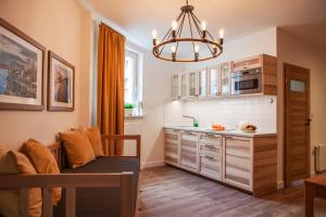 a small kitchen with a couch and a chandelier at Apartamenty Pocztowa in Bydgoszcz