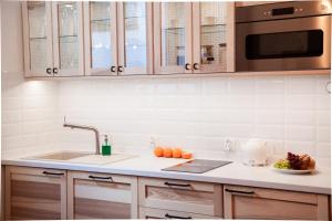 a kitchen with a sink and a microwave at Apartamenty Pocztowa in Bydgoszcz