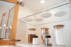 a kitchen counter with three glass containers on a shelf at Apartamenty Pocztowa in Bydgoszcz