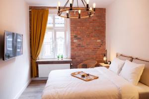 a bedroom with a bed with a tray on it at Apartamenty Pocztowa in Bydgoszcz