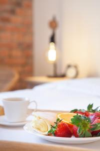 a plate of fruit and a cup of coffee on a table at Apartamenty Pocztowa in Bydgoszcz