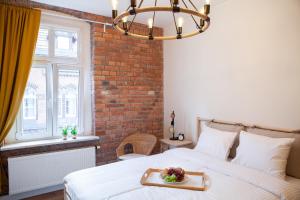 a bedroom with a bed with a tray of food on it at Apartamenty Pocztowa in Bydgoszcz