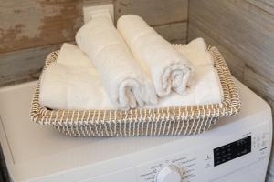 a basket of towels sitting on top of a washing machine at Apartamenty Pocztowa in Bydgoszcz