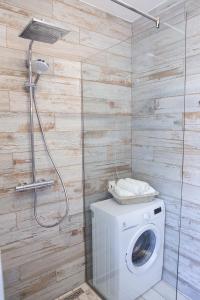 a washing machine in a bathroom with a shower at Apartamenty Pocztowa in Bydgoszcz +37 photos
