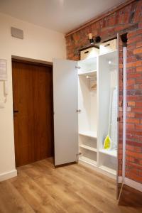 a room with a brick wall and a closet at Apartamenty Pocztowa in Bydgoszcz
