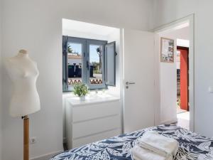 Habitación blanca con cama y ventana en Casa da Fonte / Fountain House, en Monsaraz