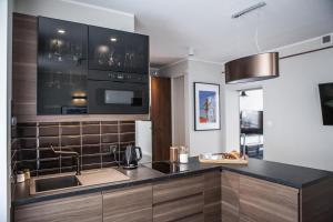 a kitchen with a counter with a sink and a microwave at Apartamenty Pocztowa in Bydgoszcz