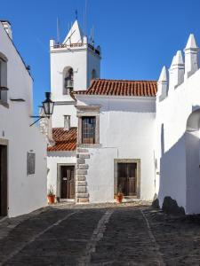 a white building with a clock tower at Casa da Fonte / Fountain House in Monsaraz