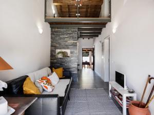 a living room with a couch and a brick wall at Casa da Fonte / Fountain House in Monsaraz