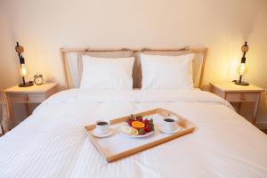 a tray with a plate of food on a bed at Apartamenty Pocztowa in Bydgoszcz