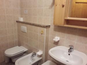 a bathroom with a white toilet and a sink at Locanda Da Pierina in Santo Stefano di Cadore