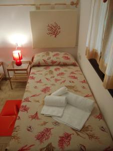 a small room with a bed with towels on it at Casa Alessia in Villasimius