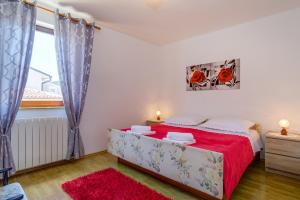 a bedroom with a bed and a window at Apartment Budinic in Mali Lošinj
