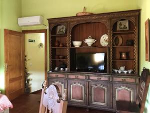 um grande armário de madeira com uma televisão num quarto em Casa Barrero em Robledillo de Gata