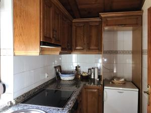 a kitchen with wooden cabinets and a black counter top at Casa Barrero in Robledillo de Gata