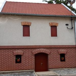 un edificio de ladrillo rojo y blanco con puertas rojas en Penzion Na Vyhlídce en Čejkovice