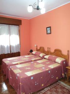 a bedroom with a large bed with orange walls at Apartamentos Rurales Pernús in Colunga