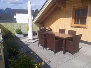 patio ze stołem i krzesłami na tarasie w obiekcie Ferienwohnung Grimmingblick w mieście Bad Mitterndorf